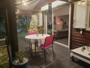 a table and chairs on a patio with a christmas tree at LA KAZ A DIAMANTS in Saint-Denis