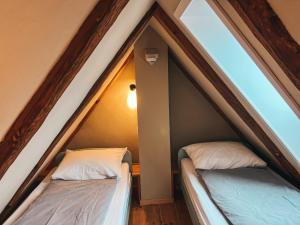 two beds in a pitched room with two windows at Kyritzer Budenhaus (Nr. 105) in Kyritz