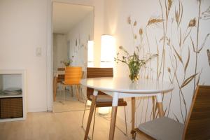 une salle à manger avec une table et un vase de fleurs dans l'établissement Landhaus Refugium, à Weissach