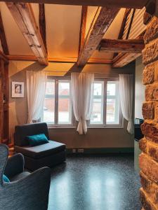 ein Wohnzimmer mit einem Sofa und 2 Fenstern in der Unterkunft Kyritzer Budenhaus (Nr. 105) in Kyritz