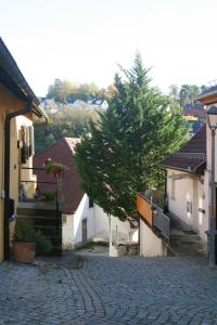 une rue pavée dans une ville avec un arbre dans l'établissement Landhaus Refugium, à Weissach