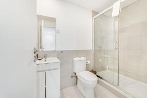 uma casa de banho branca com um WC e um chuveiro em Fornos Deluxe Apartments em Lisboa
