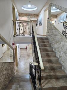 uma escada numa casa com uma parede de pedra em Olympic Apartments Wellness & Spa em Belgrado
