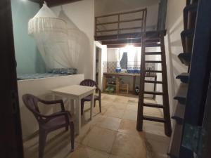 a room with a table and chairs and a bunk bed at Casa INTI de Maracajaú in Maracajaú