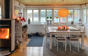 a kitchen and dining room with a table and a fireplace at Lovely Home In Hjltevad With House Sea View in Hjältevad