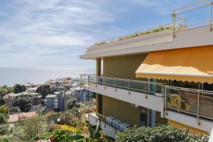 een gebouw met een balkon met uitzicht op de oceaan op de achtergrond bij Appartamento-Sanremo my Home Free parking-Wi-fi in Sanremo