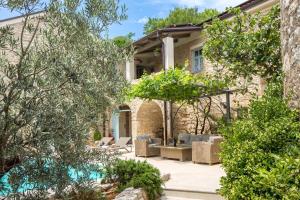 a house with a courtyard with chairs and trees at Villa Ivka in Tribalj