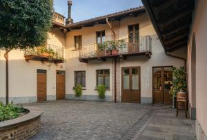 ein Gebäude mit zwei Balkonen und einem Innenhof in der Unterkunft Il Giardino di Ghilot in Cherasco