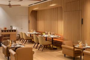 a restaurant with tables and chairs in a room at EVOLUTION Cascais-Estoril Hotel in Estoril