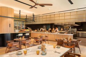 a restaurant with wooden tables and chairs and a kitchen at EVOLUTION Cascais-Estoril Hotel in Estoril