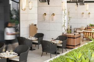 a restaurant with tables and chairs and a person in the background at EVOLUTION Cascais-Estoril Hotel in Estoril