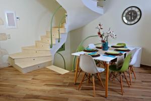 a dining room with a table and chairs and stairs at Petra & Thalassa in Plataria