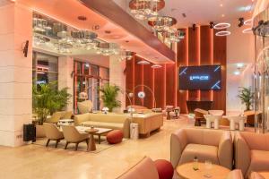 a lobby with couches and tables and a tv at EVOLUTION Cascais-Estoril Hotel in Estoril