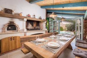 a dining room with a wooden table and an oven at Villa Ivka in Tribalj