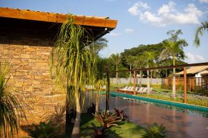 a resort with a swimming pool and a stone wall at Tiradentes Boutique Hotel in Tiradentes