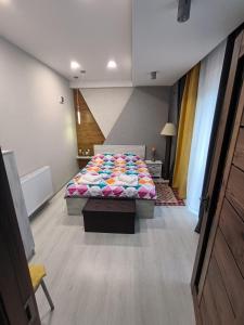 a bedroom with a bed with a colorful comforter at guest house Calma in Telavi