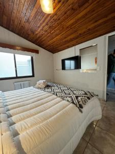 - une chambre avec un grand lit et un plafond en bois dans l'établissement El Residencial Bariloche, à San Carlos de Bariloche