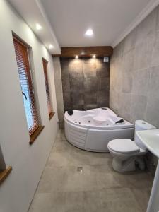 a bathroom with a tub and a toilet and a sink at guest house Calma in Telavi