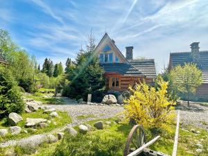 a log cabin with a garden in front of it at GORSKA OSADA Lovely Chalets Zakopane in Poronin