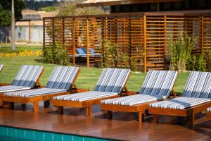 a group of four chairs sitting next to a pool at Tiradentes Boutique Hotel in Tiradentes