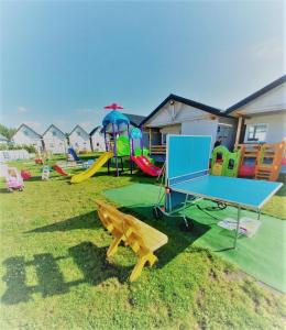 a playground with a ping pong table and slides at Domki Flaming in Dąbki