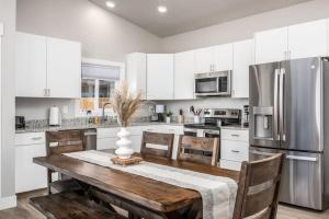 a kitchen with a wooden table and a refrigerator at High Desert luxury with views for families in Kanab
