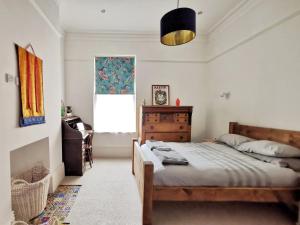 a bedroom with a bed and a dresser and a window at Church Retreat - A Magnificent Sea Side Apartment in Hastings