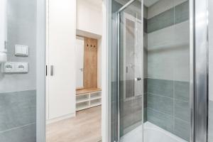 a bathroom with a shower with a glass door at MyMozart apartments by Rentero property in Prague