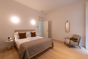 um quarto com uma cama grande e uma cadeira em Mouzinho 32 em Porto
