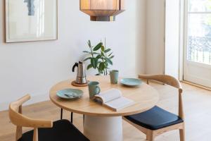 een houten tafel met twee stoelen en een boek erop bij Mouzinho 32 in Porto