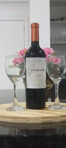 - une bouteille de vin à côté de deux verres à vin dans l'établissement Apartamentos na cobertura - Edifício London, à Piratuba
