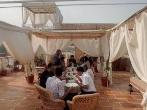 een groep mensen die aan tafels onder een tent zitten bij Kiran Apartment in Jaisalmer