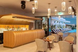 a restaurant with a bar with chairs and a pool at EVOLUTION Cascais-Estoril Hotel in Estoril