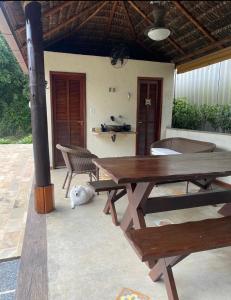 a dog laying next to a picnic table on a patio at Casa rosa de Guapimirim in Guapimirim +28 photos
