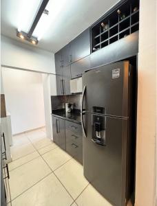 a kitchen with a stainless steel refrigerator and black cabinets at Casa valle oriente in Saltillo