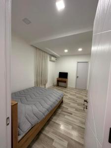 1 dormitorio con 1 cama grande y TV en Noes home en Mtskheta