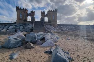 a castle on the beach with rocks in front of it at The Family Van - Withernsea in Waxholme