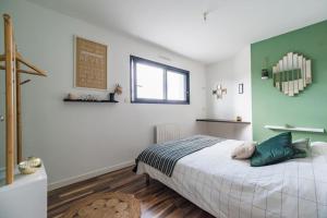 a bedroom with a bed and a green wall at Maison de vacances à Pordic - proche de la mer in Pordic