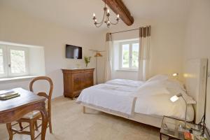 Un dormitorio con una cama, una mesa y una silla. en Authentique propriété, en Bonnieux 22 fotos más