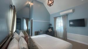 a bedroom with a bed and a flat screen tv at Vermont Khao Yai Resort in Ban Na Sok