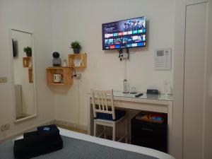 a room with a desk with a tv on the wall at Rose Antiche Vatican B&B in Rome