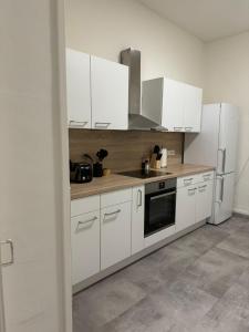 a kitchen with white cabinets and white appliances at BK Apartments in Lörrach