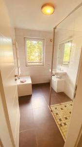 a bathroom with a shower and a sink and a mirror at Haus Am Strand in Juliusruh