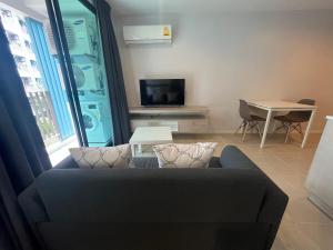 a living room with a couch and a table at 1 bedroom Centrio Condominium Phuket Near Central Foresta Cental Festival in Ban Rangeng