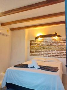 um quarto com uma cama com uma parede de tijolos em Moon Wind Tayrona Hostel by Rotamundos em El Zaino