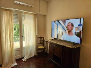 a flat screen tv sitting on a stand in a living room at A Friendly Room in the Heart of Recoleta -in Shared Apartment- in Buenos Aires