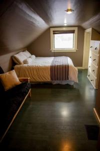 a small bedroom with a bed and a window at The Cozy Red Cabin in Bellevue