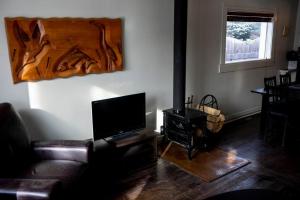 uma sala de estar com um sofá e uma televisão de ecrã plano em The Cozy Red Cabin em Bellevue