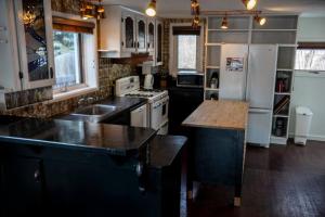 a kitchen with black counters and a white refrigerator at The Cozy Red Cabin in Bellevue