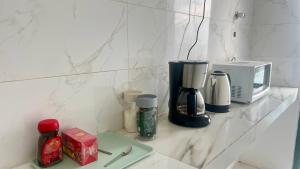 a counter with a coffee maker and a microwave at Wadi Shab Beach Resort in Ţīwī